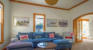 Ein Wohnzimmer mit einem blauen Sofa, einem Couchtisch und gerahmten Bildern an der Wand.