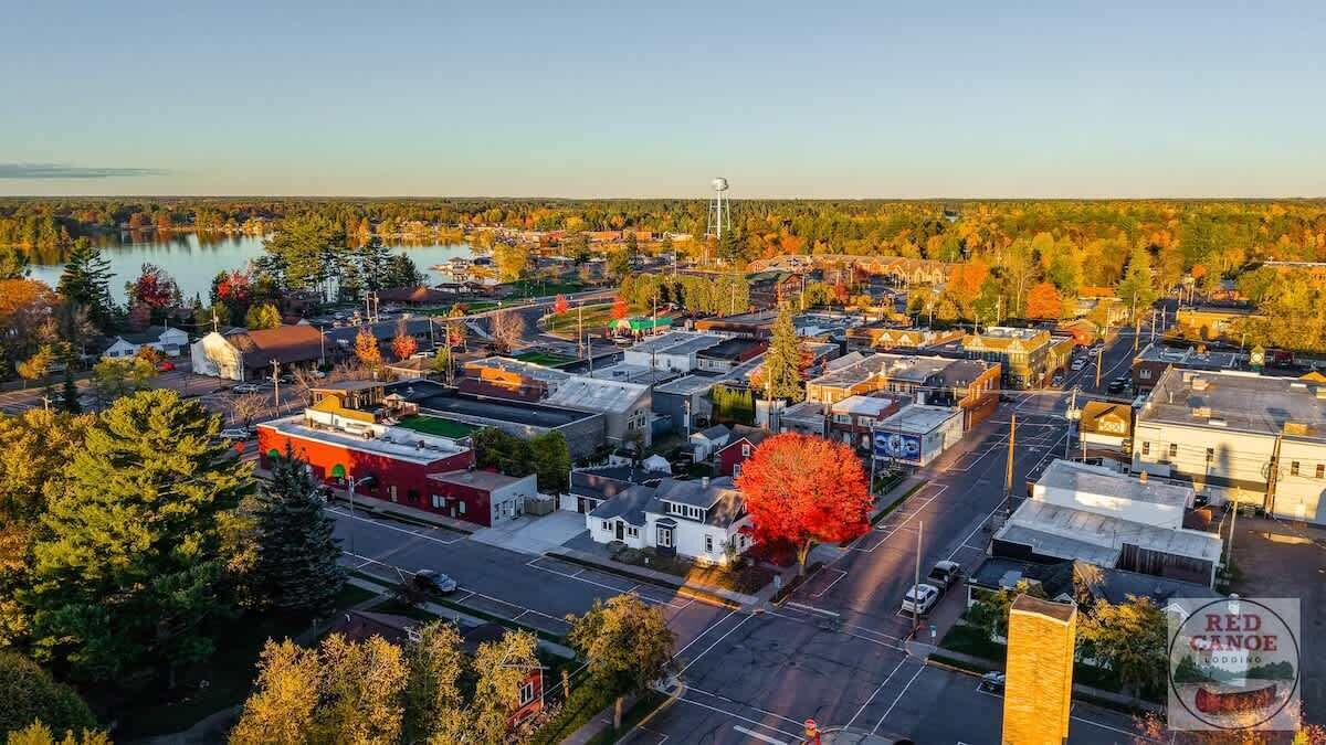 An aerial view of a town with buildings, roads, and a lake.