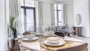 Ein Essbereich mit einem Tisch für vier Personen, einer Chandelüster und Blick ins Freie.