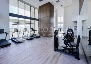 A modern gym with treadmills, elliptical machines, and weight equipment. - 1015 Bloomfields Spacious 1BR Aziz Fawad (Dubai)