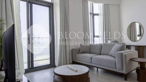 Ein modernes Wohnzimmer mit Sofa, Couchtisch und Fernseher.
