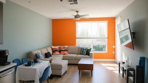 A modern living room with a sofa, coffee table, and dining area.