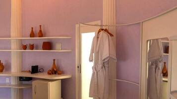 A bathroom with a vanity, a mirror, and a robe hanging on a rack.