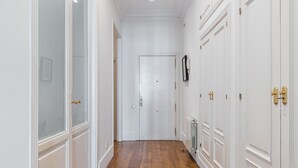 A hallway with white doors, a radiator, and a framed picture on the wall. - Waou Sol VII - Short Term Rental (Madrid)