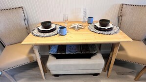 Ett matbord med två stolar, en liten bänk och en förvaringslåda under bordet.