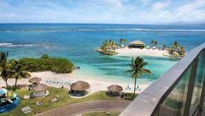 Ein Resort mit Strand, Palmen und klarem, blauem Wasser.