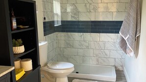 A modern bathroom with a toilet, shower, and sink. - Modern One bedroom Near Bishops Arts District (Dallas)