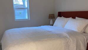 A bedroom with a bed, a window, and a nightstand with a lamp. - Modern One bedroom Near Bishops Arts District (Dallas)