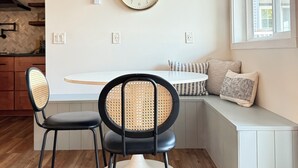 A modern kitchen with a wooden ceiling fan, a round dining table, two chairs, and a built-in bench with cushions. - HAVEN COTTAGE - Close to Mpls, Far From Your Routine-FREE SUPS on Lake Fremont! (Zimmerman)