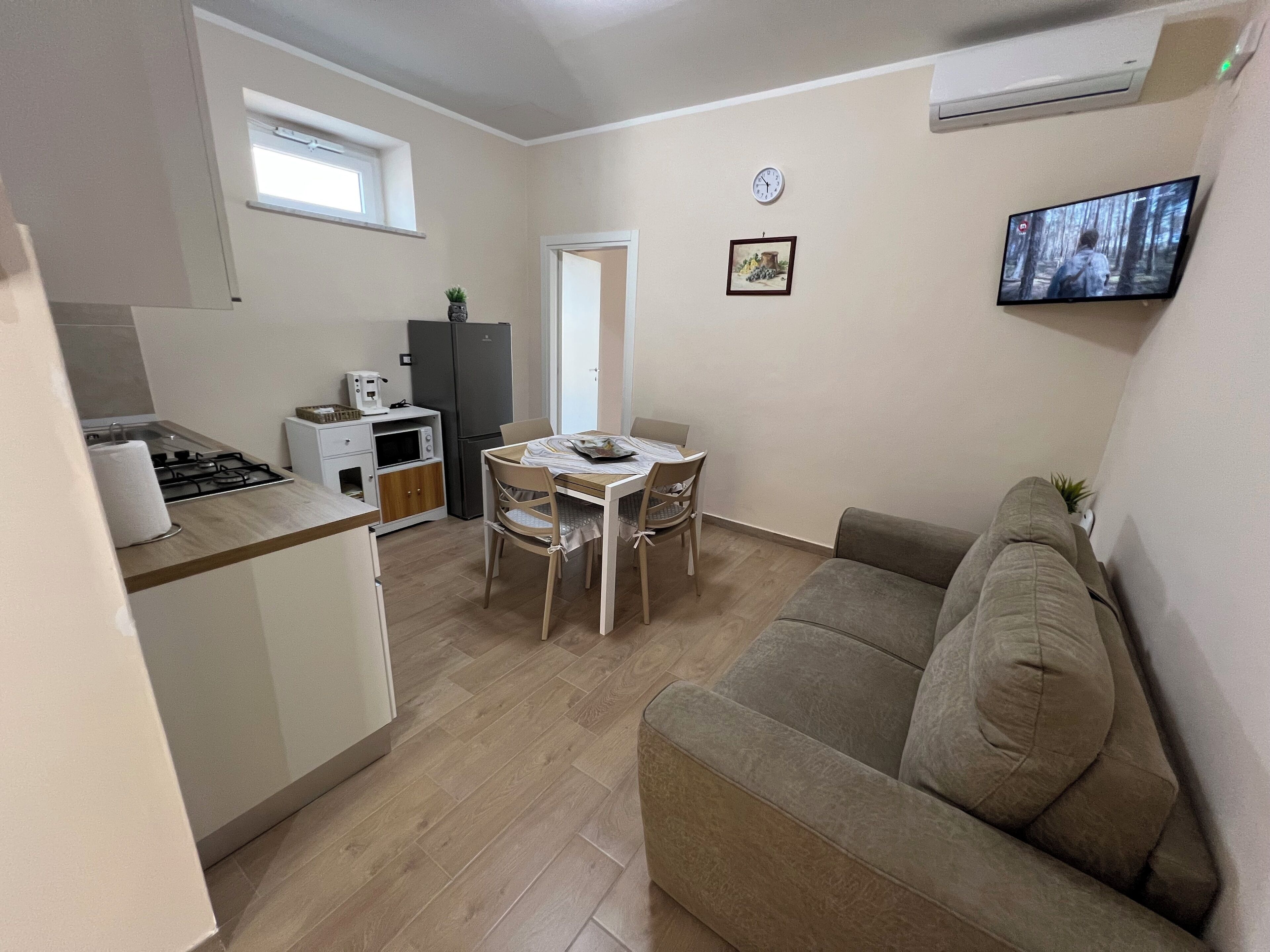 A compact living space with a kitchenette, a dining area, and a seating area.