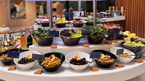 Ein reichhaltiges Buffet mit verschiedenen Speisen, darunter Oliven, Salate und Früchte.