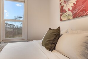 A bedroom with a bed, a window, and a painting on the wall. - Downtown Snohomish - River Views - Walk to Town (Snohomish)