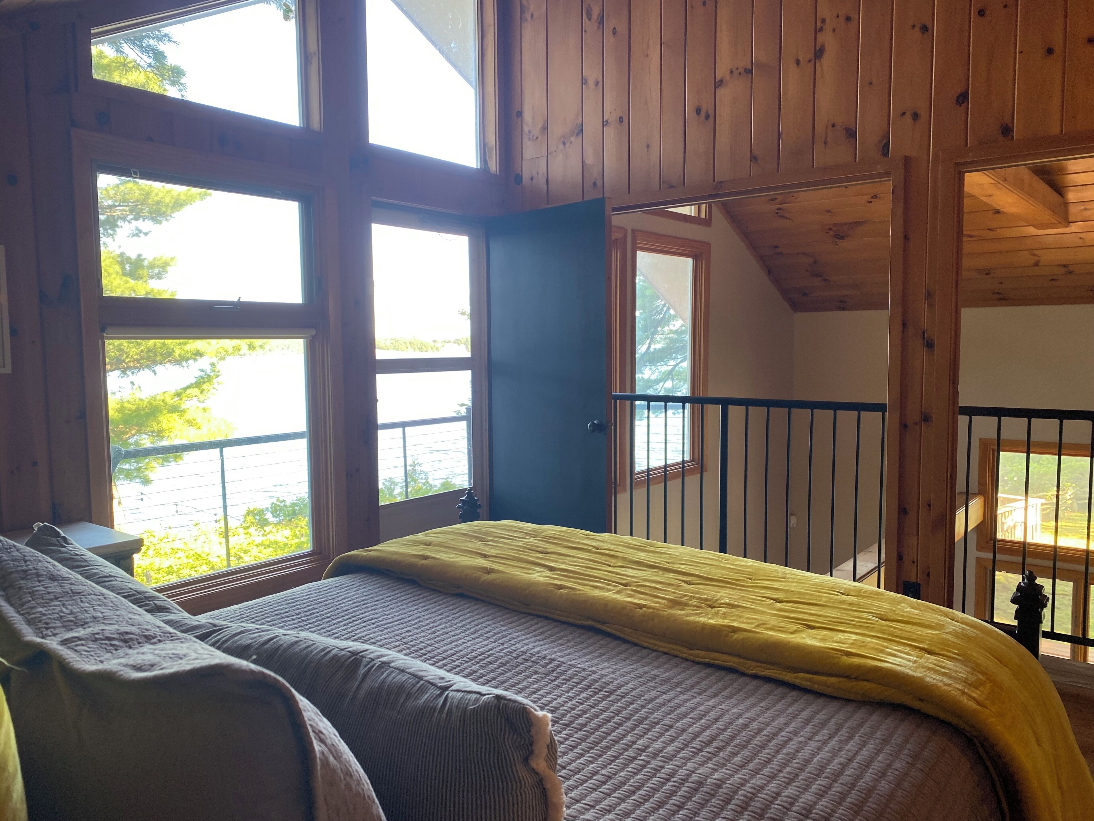 Una habitación con cama, ventana y balcón.