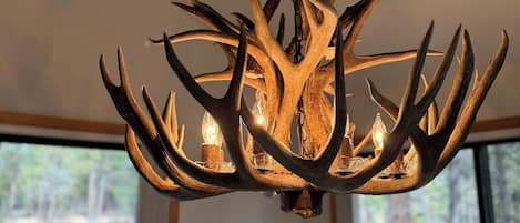 A chandelier with antler-shaped metal branches and candles.