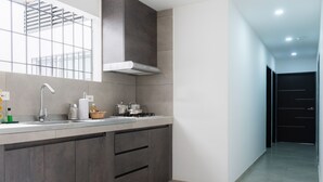 Une cuisine moderne dotée d’une grande fenêtre, d’une cuisinière encastrée et d’un meuble en bois foncé.