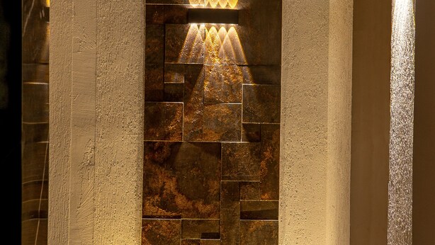 Un intérieur moderne avec un mur en pierre et un éclairage encastré.