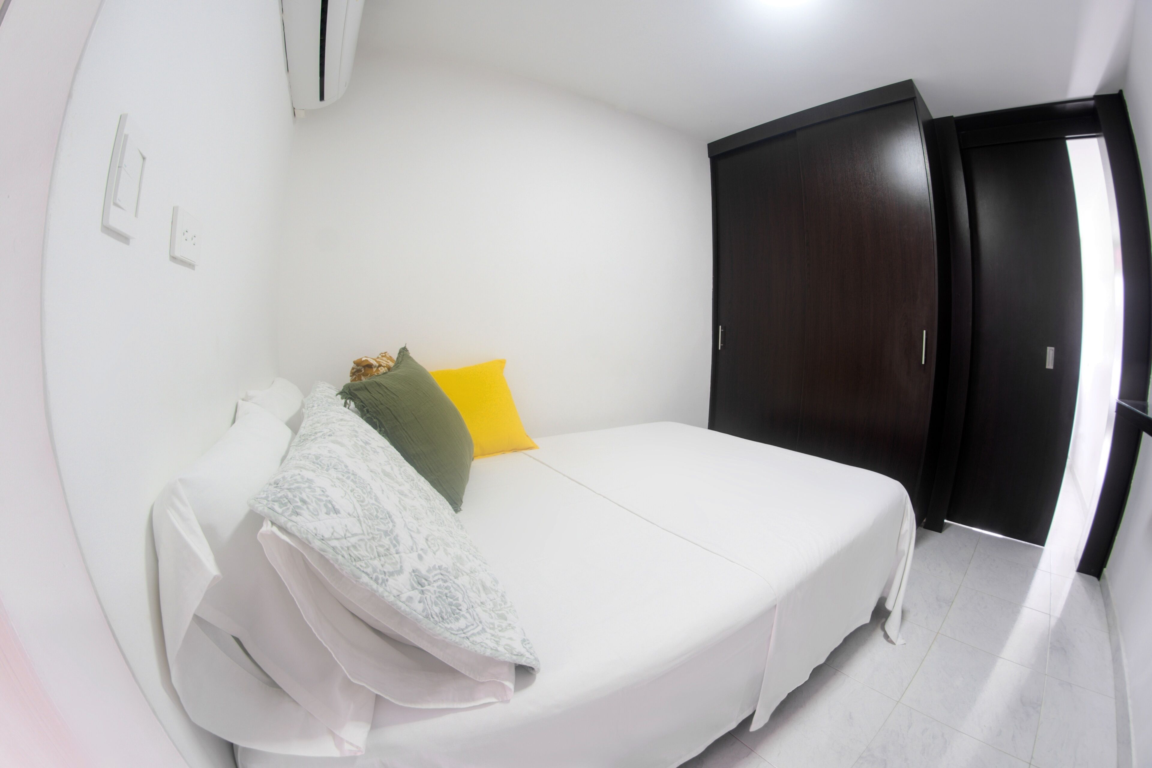 A bedroom with a bed, a wardrobe, and a door.