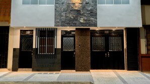 Un bâtiment moderne doté d’une façade en pierre, de plusieurs entrées et d’un hall d’entrée bien éclairé.
