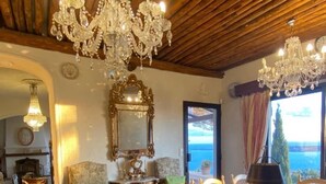 A dining area with a wooden table and chairs, a chandelier, and a view of the sea. - Sumptuous Mediterranean villa in Cannes (Cannes)