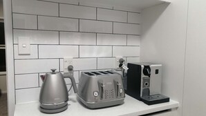 A kitchen counter with a coffee maker, toaster, and kettle. - Auckland Takapuna 2B Unit & Netflix (North shore)