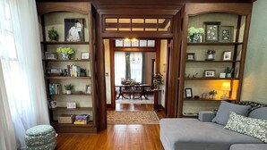 Ein Wohnzimmer mit einer Couch, einem Couchtisch, einem Teppich und einem Bücherregal.