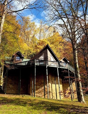A cabin with a stone foundation, a balcony, and a small attached shed. - Cozy 3BR Log Cabin, 5 minutes to Center Hill Marina, Gated Community, Sleeps 10 (Lancaster)