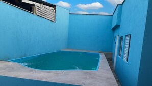 Une piscine aux carreaux bleus, avec un ciel bleu clair en arrière-plan.
