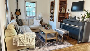 Una sala de estar acogedora con un sofá, una mesa de centro y un piano.