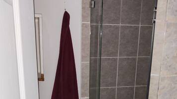 Een douche, handdoeken, zeep, toiletpapier