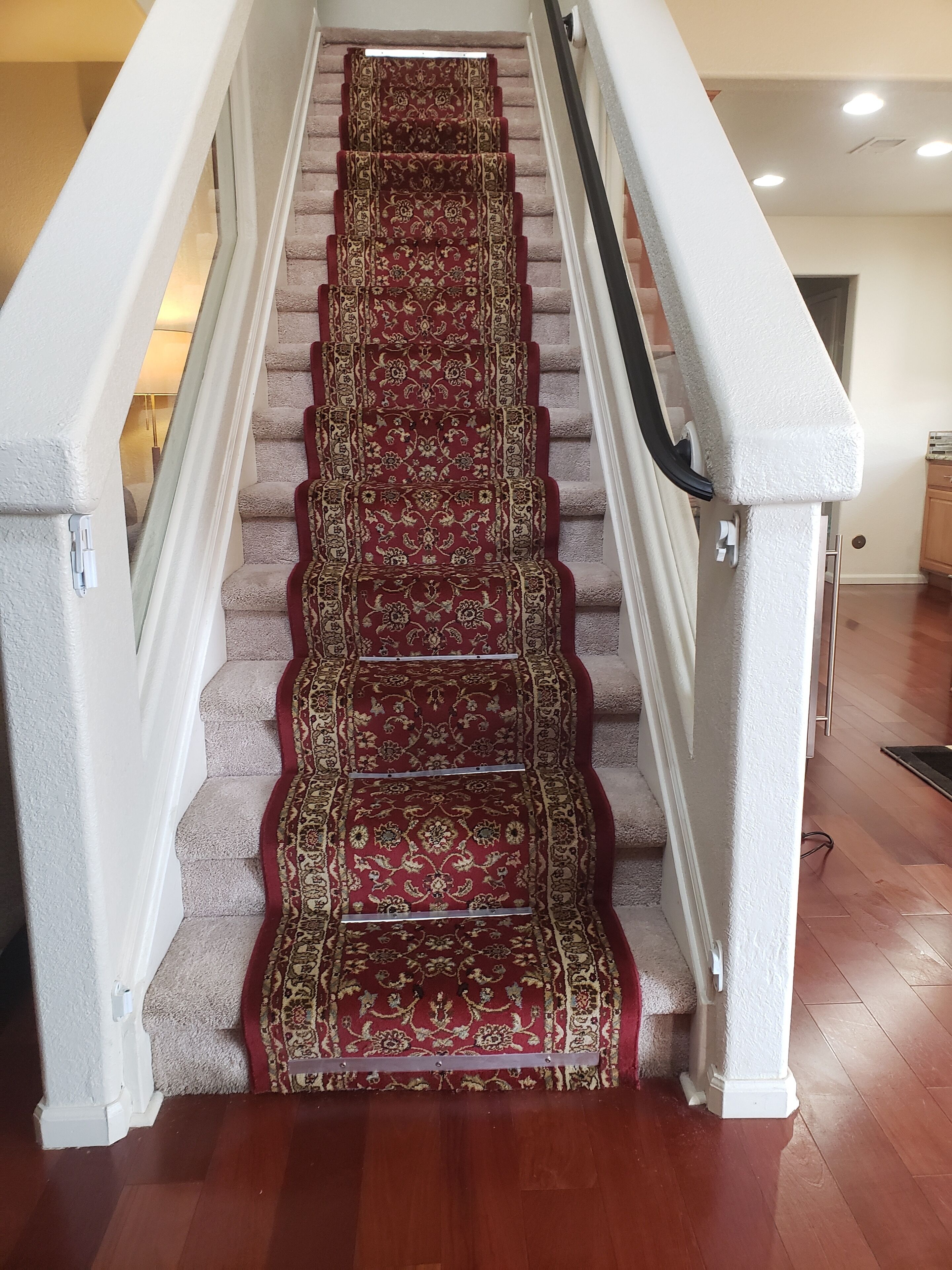 Een trap met een rood tapijt en witte balustrades.