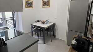 Une cuisine compacte comprenant un coin repas, un réfrigérateur et un four à micro-ondes.