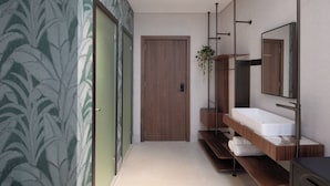 Een moderne badkamer met een houten wastafelmeubel, een grote spiegel en behang met een bladmotief.