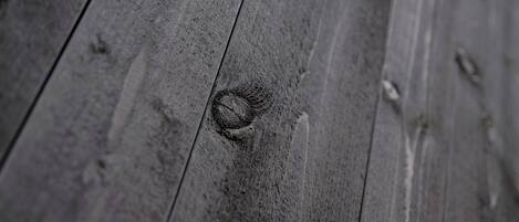 A close-up of a wooden surface with visible grain and knots.