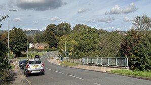 A road with cars parked on the side, a bus stop, and a guardrail. - Comfortable Room in a shared apartment. (Cardiff)