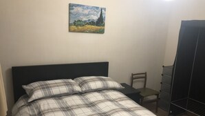 A bedroom with a bed, a chair, a nightstand, a dresser, and a painting on the wall. - Comfortable Room in a shared apartment. (Cardiff)