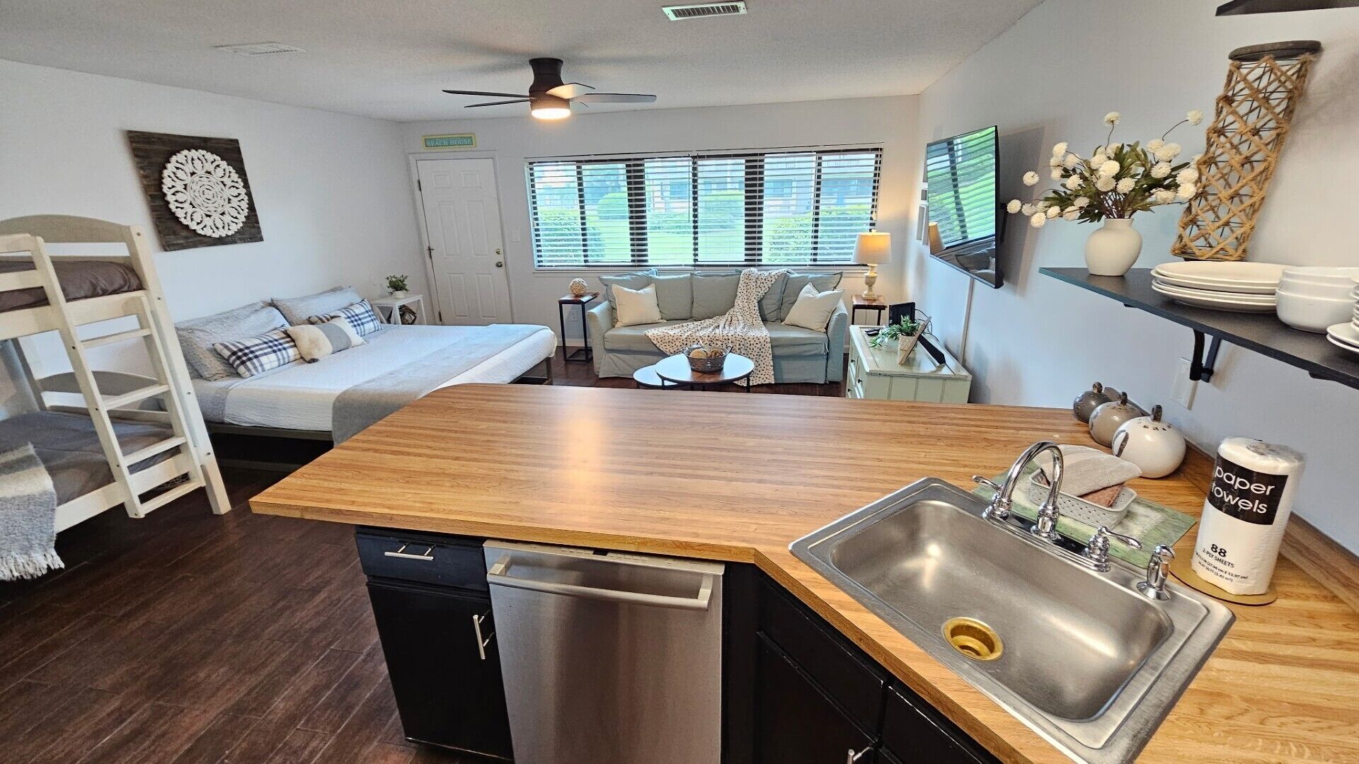 A compact living space with a kitchenette, a bed, a sofa, and a dining area.