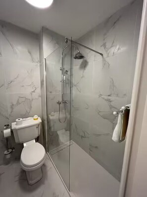 Een haardroger, handdoeken, zeep, toiletpapier