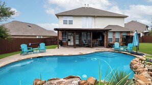 A backyard with a swimming pool, a covered patio area, and a house with a two-story design. - Family Home - Private Pool - Office - Pet Friendly (Fort Worth)