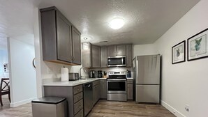 A modern kitchen with stainless steel appliances, wooden cabinets, and a tiled floor. - Extended Ski/Work/Visit secluded Cul-da-sac cutie (Salt Lake City)