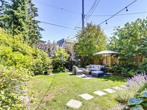 A backyard with a patio area, a garden, and a pergola. - Cozy Private 2BR Garden Suite in Central Vancouver (Vancouver)
