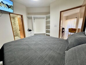 Ein Schlafzimmer mit einem Bett, einem Schrank, einem Schreibtisch und einem Stuhl.