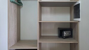 A closet with wooden shelves, a hanging rack, and a small safe. - Romantic Studio: Ocean, Salt Pans with Flamingos & Infinity Pool (Willemstad)