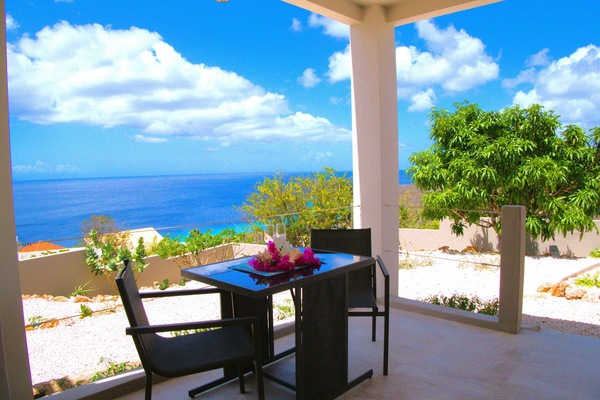 Covered terrace with dining table overlooking the Caribbean