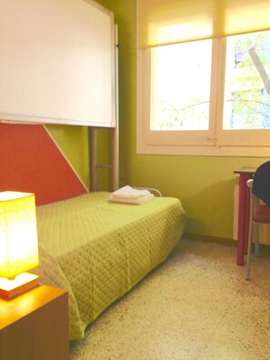 A room with a bed, a desk, and a window. - Hostel Albergue Studio (Barcelona)