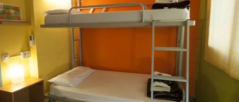 A bunk bed room with a nightstand and a wall-mounted shelf.
