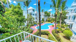 Ein Resort mit Schwimmbad, umgeben von üppiger Vegetation und Palmen.