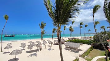 En la playa, playa de arena blanca y 4 bares en la playa