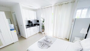 Ein Hotelzimmer mit einem Bett, einer kleinen Küchenzeile und einem Badezimmer.