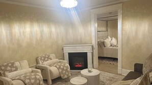 Un salon avec une cheminée, deux canapés, une table basse et un tapis.