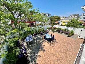 A patio area with a table and chairs, surrounded by plants and a white fence. - Spacious 4-bedroom house with a view of the inlet beach in North Wildwood (North Wildwood)